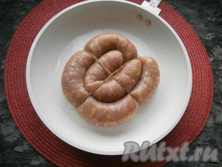 Разместить колбасу в любой удобной форме для запекания (или в сковороде со снятой ручкой), на дно которой влить около 50-70 мл воды.
