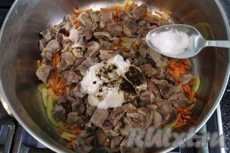 В кастрюлю (или сковороду) с обжаренными овощами выкладываем нарезанные куриные желудочки, добавляем соль по вкусу, сметану, горошинки чёрного перца, чёрный молотый перец.