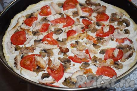 Далее распределяем по всей поверхности пиццы кусочки обжаренной курицы.