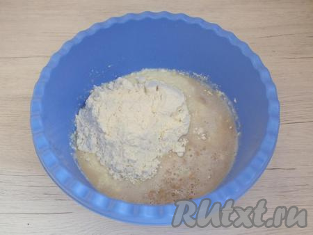 Всыпьте 1/4 часть муки, перемешайте ложкой.