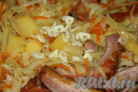 По истечении времени добавить в сковороду соль, специи, очищенный чеснок, нарезанный на тонкие лепестки, перемешать и тушить под крышкой 10 минут.