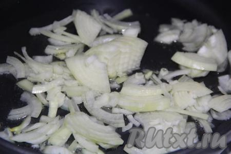 Лук почистить и нарезать полукольцами. В сковороду с высокими бортиками влить растительное масло и добавить лук.