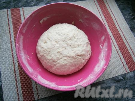 И далее, вливая оставшуюся тёплую воду, замешивать тесто вначале ложкой, а потом руками. Вымешивать тесто долго не нужно, оно должно просто стать плотным и не липнущим. Смазать тесто 1 столовой ложкой растительного масла, вмешать его.