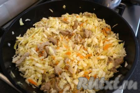 К свинине, луку и моркови выкладываем подготовленную капусту и аккуратно перемешиваем.