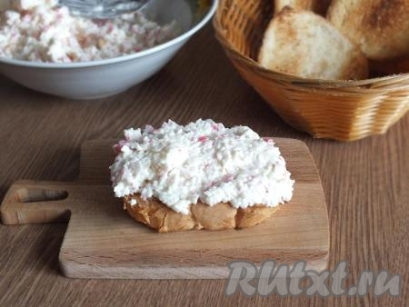 Возьмите обжаренный ломоть батона и покройте его массой из крабовых палочек и плавленного сыра. Количество массы определяйте самостоятельно. Я выкладывала по 1,5 столовых ложки массы.
