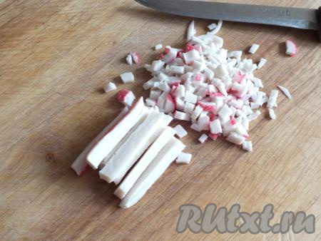 Оттаявшие крабовые палочки нарежьте на очень мелкие кубики (обычно я разрезаю палочку на три части вдоль и ещё один раз поперёк, а затем режу на мелкие кубики).