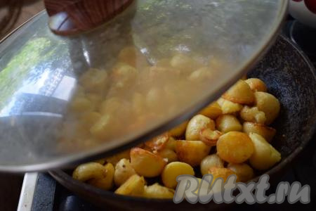 Жарим молодую картошку в кожуре, накрыв сковороду крышкой и периодически перемешивая, до готовности. Продолжительность приготовления у всех будет разной, так как многое зависит от сорта картофеля, его размера, диаметра сковороды и во сколько слоёв вы выложите клубни. В среднем на жарку картошки по этому рецепту уходит 35-40 минут.