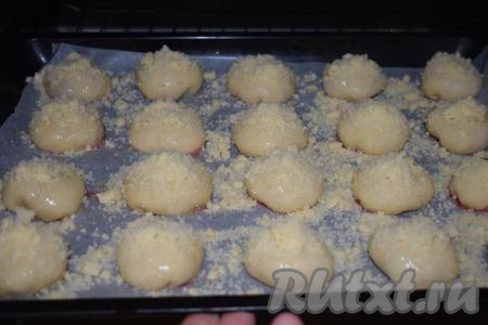 С помощью кулинарной кисти смазываем булочки яйцом, взбитым вилкой. Достаём из холодильника штрейзель и посыпаем им булочки с клубникой. Отправляем дрожжевую выпечку в разогретую духовку и выпекаем при температуре 180 градусов, примерно, 35-40 минут.