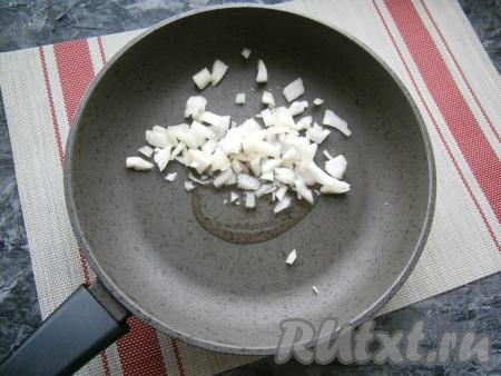 Растительное масло влить в сковороду, добавить очищенный и нарезанный на средние кусочки репчатый лук.