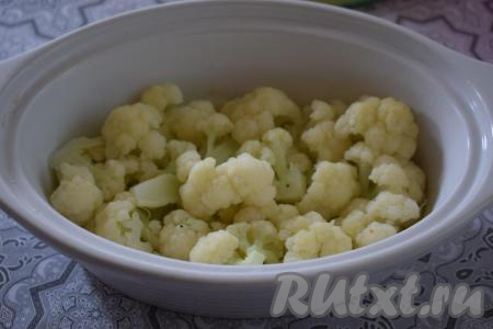 Форму для запекания смазываем сливочным маслом. Я запекаю куриную грудку с цветной капустой в керамической форме объёмом 1,5 литра. На дно формы выкладываем половину цветной капусты.