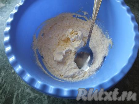 К получившейся творожной массе добавьте мягкое (не растопленное!) масло, хорошо перемешайте ложкой.
