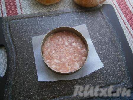 Также добавить сюда и перекрученный на мясорубке (или натёртый на мелкой тёрке) репчатый лук, фарш тщательно перемешать и хорошенько отбить о дно миски. Разделить получившийся фарш на 4 части, сформировать круглые, плотные котлеты с помощью кулинарного кольца диаметром побольше булочек (или можно взять нужного диаметра консервную банку, срезав её дно и верх). Каждую котлету формировать на листике пергамента, немного смазанного растительным маслом.
