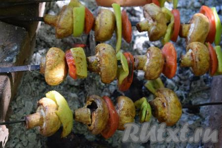 Отправляем шашлык на мангал. Жарим овощной шашлык с шампиньонами на седых углях, примерно, 15 минут, постоянно поворачивая шампуры из стороны в сторону.