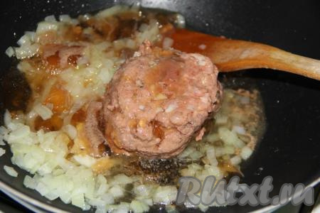 Затем в сковороду с обжаренным луком выложить говяжью тушёнку и разбить её с помощью деревянной лопатки на мелкие части, прогреть несколько минут на среднем огне.