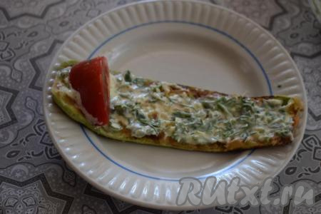 Далее каждый язычок смазываем чесночным соусом (на каждую полосу кладём около 1 чайной ложки соуса). На широкую сторону язычка кладём дольку помидорчика.