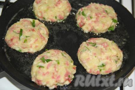 Масса получится не жидкой, липкой и вязкой. Сформировать руками, смоченными в воде, из получившейся массы круглые оладьи. На сковороду, разогретую с растительным маслом, выложить получившиеся оладушки.