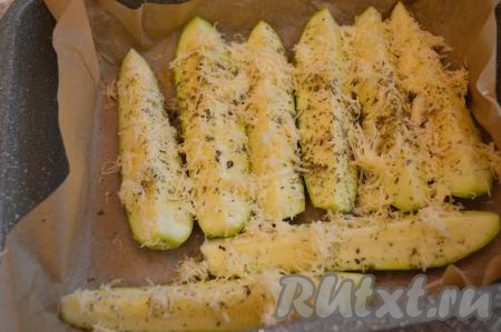 Затем каждую дольку  кабачка посыпать сухими травами, сбрызнуть оливковым маслом и сверху посыпать натёртым сыром. Часть сыра оставить для украшения.
