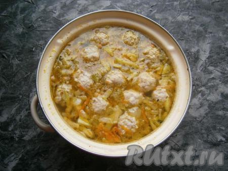 Выложить в кастрюлю с картошкой, луком, кабачками и морковкой подготовленные фрикадельки, лавровый лист и измельчённый чеснок, довести суп до кипения, а затем варить минут 10 на медленном огне и снять с огня.