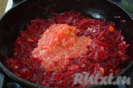 Добавляем в сковороду натёртые помидоры, перемешиваем до однородности и тушим нашу свекольную икру ещё 5-6 минут.