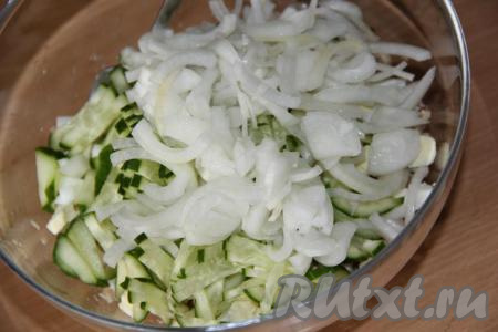 В салат из консервированной скумбрии и яиц выложить маринованный лук и нарезанный свежий огурчик. 