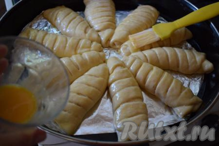 С помощью кулинарной кисти смазываем наши булочки яйцом, взбитым вилкой.