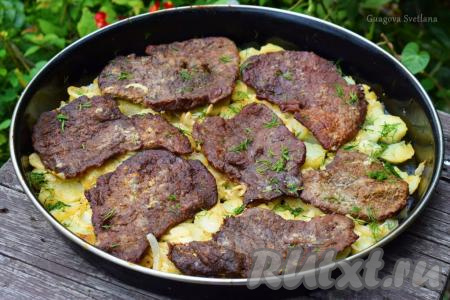 Готовые отбивные из говядину с картофелем достаём из духовки и посыпаем нарезанным укропом.