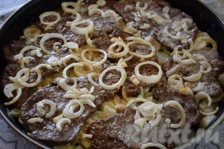 Далее на мясо кладём оставшийся лук со сметаной, наливаем 120 мл воды и отправляем форму (или противень) в разогретую духовку. Запекаем отбивные из говядины с картошкой и сметаной 1 час при температуре 180 градусов.