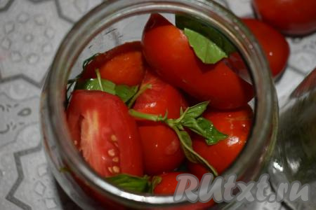Кладём на дно каждой банки по 2 кружочка лука. Заполняем каждую баночку половинками помидоров и листиками базилика, в середину выкладываем пару колечек лука и продолжаем заполнять банку до самого верха помидорами и листочками базилика.