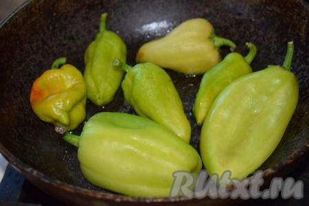 Болгарский перец, не очищая от семян и плодоножек, кладем в сковороду, разогретую с 3 столовыми ложками растительного масла. Сковорода обязательно должна быть с крышкой, перец очень сильно брызгается и "стреляет" при жарке.