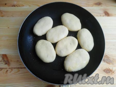 На сковороде разогреть растительное масло, выложить сформированные пирожки с лисичками швом вниз, обжаривать их на среднем огне до зарумянивания с одной стороны (по мере необходимости можно подливать масло).