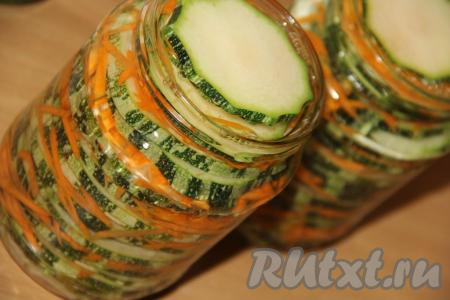 Маринад снять с огня и влить его в банки с кабачками и морковью, заполняя баночки до горлышка.