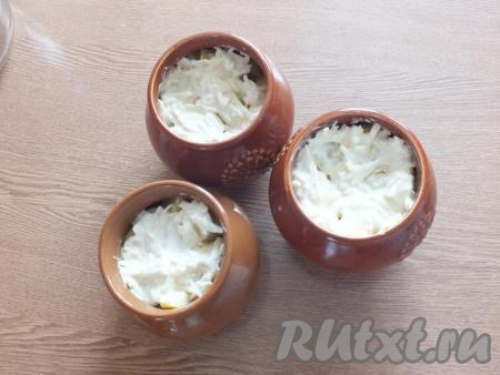 Разложите сыр со сметаной по горшочкам. Накройте горшочки с горбушей и картошкой крышками, поставьте в разогретую до 200 градусов духовку на 15 минут. После крышечки снимите и запекайте до румяной корочки (минут 10).
