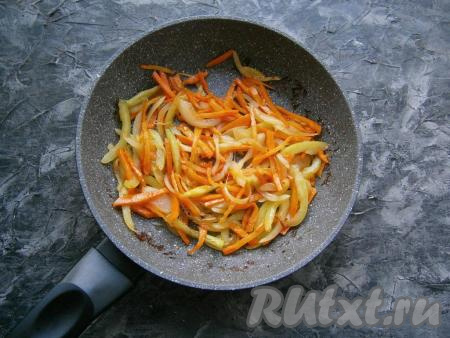 Переложить мясо на тарелку, а в сковороду влить оставшиеся 2 столовые ложки растительного масла, выложить лук, болгарский перец и морковь, обжарить их, иногда помешивая, до мягкости (в течение минут 7) на среднем огне.