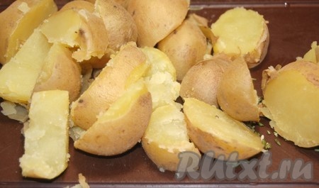 Нарезать горячий  отварной картофель в мундире на крупные кусочки.