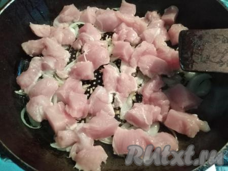 В сковородку к луку и чесноку добавляем кусочки индюшиного филе, перемешиваем. Жарим на среднем огне, периодически помешивая, пока филе не побелеет (это займёт около 5 минут).