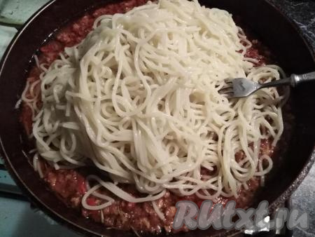 Отваренные спагетти выкладываем в мясной соус болоньезе. 