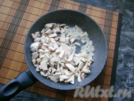 Морковь и лук очистить. Сковороду с маслом и грибами разогреть, добавить в неё луковицу, нарезанную небольшими кусочками, обжарить на среднем огне минуты 2-3, не забывая иногда перемешивать.