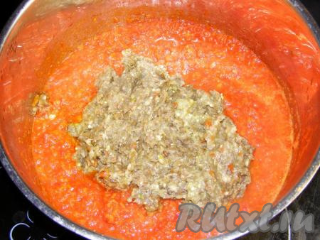 Прокручиваем через мясорубку очищенные баклажаны, чеснок и острый перец, перекладываем в кастрюлю, в которой варятся помидоры с перцами.
