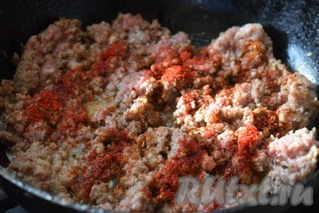 В сковороде разогреем растительное масло, выложим фарш и обжарим на слабом огне до изменения цвета, помешивая и разбивая комочки мяса. Далее добавим к фаршу специи по вкусу, паприку.
