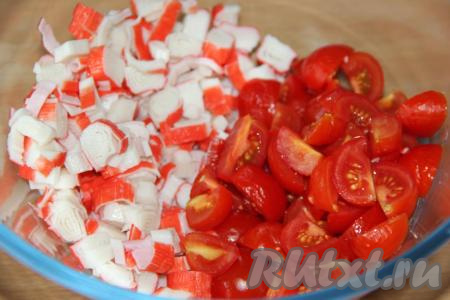 Вымыть помидоры и нарезать (помидорчики черри нужно разрезать пополам, если будете использовать более крупные помидоры, тогда  разрежьте их на несколько частей). В салатнике соединить нарезанные крабовые палочки и помидоры.