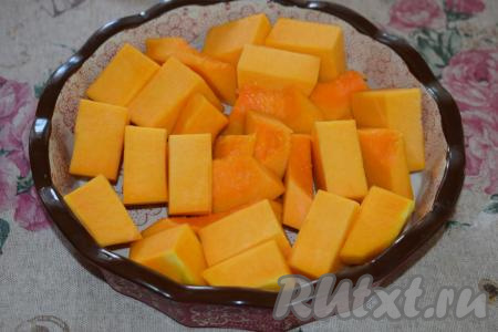 Затем берём форму для запекания (я взяла керамическую форму) и смазываем дно 1 чайной ложкой сливочного масла. В форму выкладываем кусочки тыквы.