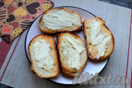 Сторону ломтей батона, натёртую чесноком, смазать сливочным маслом.