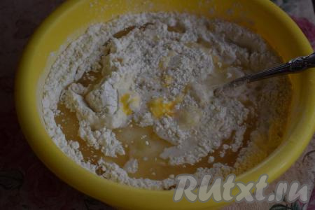 Сюда же добавляем яйцо и растительное масло, начинаем замешивать тесто. Сначала при помощи ложки, как только тесто свернётся в ком, продолжаем замес руками.