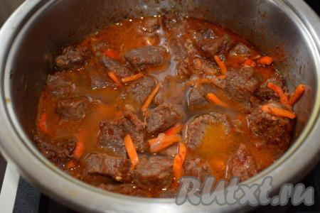 Вливаем воду к говядине с овощами. Воды не должно быть много, она должна немного покрывать кусочки мяса. Пробуем подливу на вкус, солим и перчим по необходимости. Накрываем кастрюлю крышкой и тушим мясо с овощами на медленном огне, примерно, 1 час.