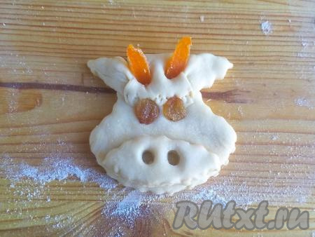 Выложить из изюма глаза. Курагу нарезать небольшими кусочками, замочить на 5 минут в горячей воде и обсушить. Вставить рожки из кураги.