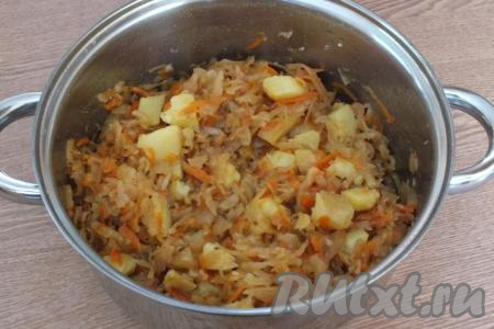 Через указанное время снимите кастрюлю с огня. Квашеная капуста, тушёная с картошкой, готова к подаче.