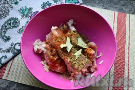 Грудинку тщательно перемешать, сжимая руками с луково-чесночной смесью, всыпать соль, чёрный молотый перец, паприку, хмели-сунели, приправу, добавить поломанный на кусочки сухой лавровый листик, перемешать и поместить в холодильник на пару часов.