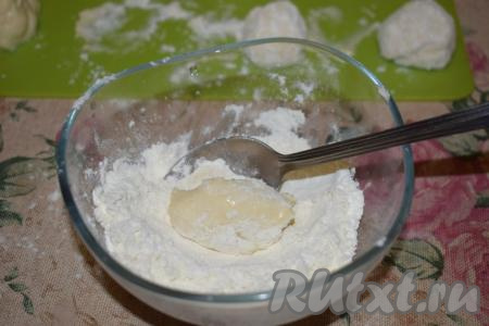 Далее от теста отделяем кусочки размером чуть больше чайной ложки и опускаем их в глубокую мисочку, в которую насыпано, примерно, 2-3 столовые ложки муки. С помощью чайной ложки обваливаем кусочек творожного теста со всех сторон в муке.