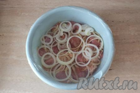 Оставшийся лук разложите на поверхности мяса. Затяните миску с кусочками свинины пищевой плёнкой и уберите в холодильник минимум на 3 часа.