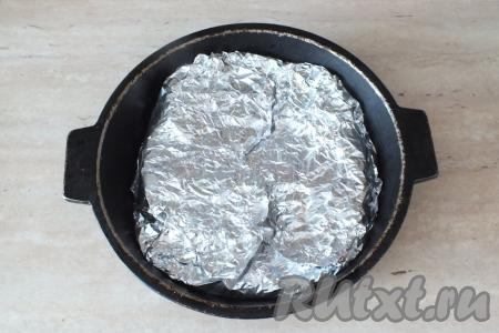 Краями фольги, свисающими с краёв формы, хорошо закройте мясо в форме. Поставьте форму со свининой, завёрнутой в фольгу, в разогретую до 200 градусов духовку на 30 минут.